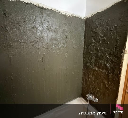 יישום חומר איטום צמנטי על קירות אמבטיה במהלך שיפוץ